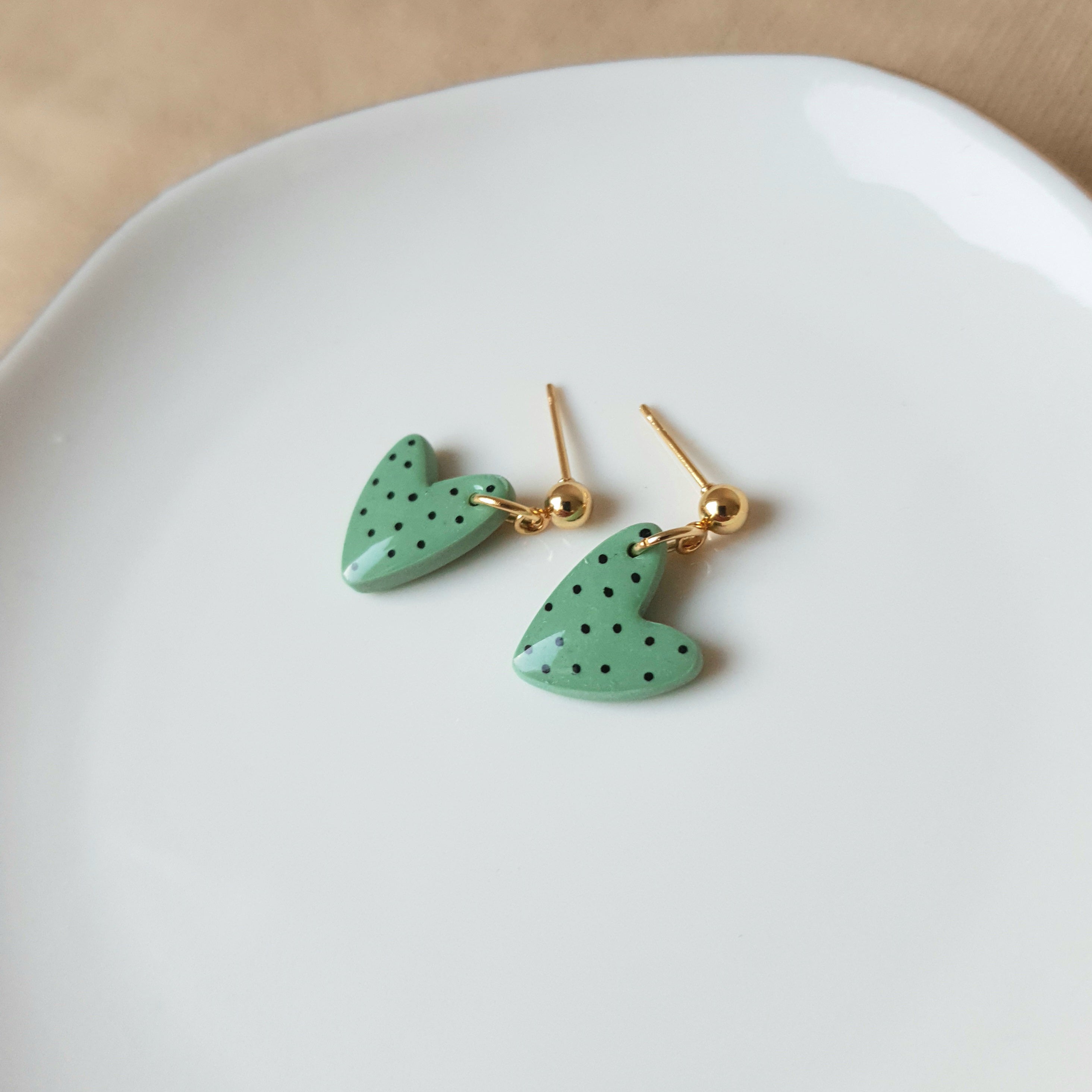 Green spotted dangly heart earrings