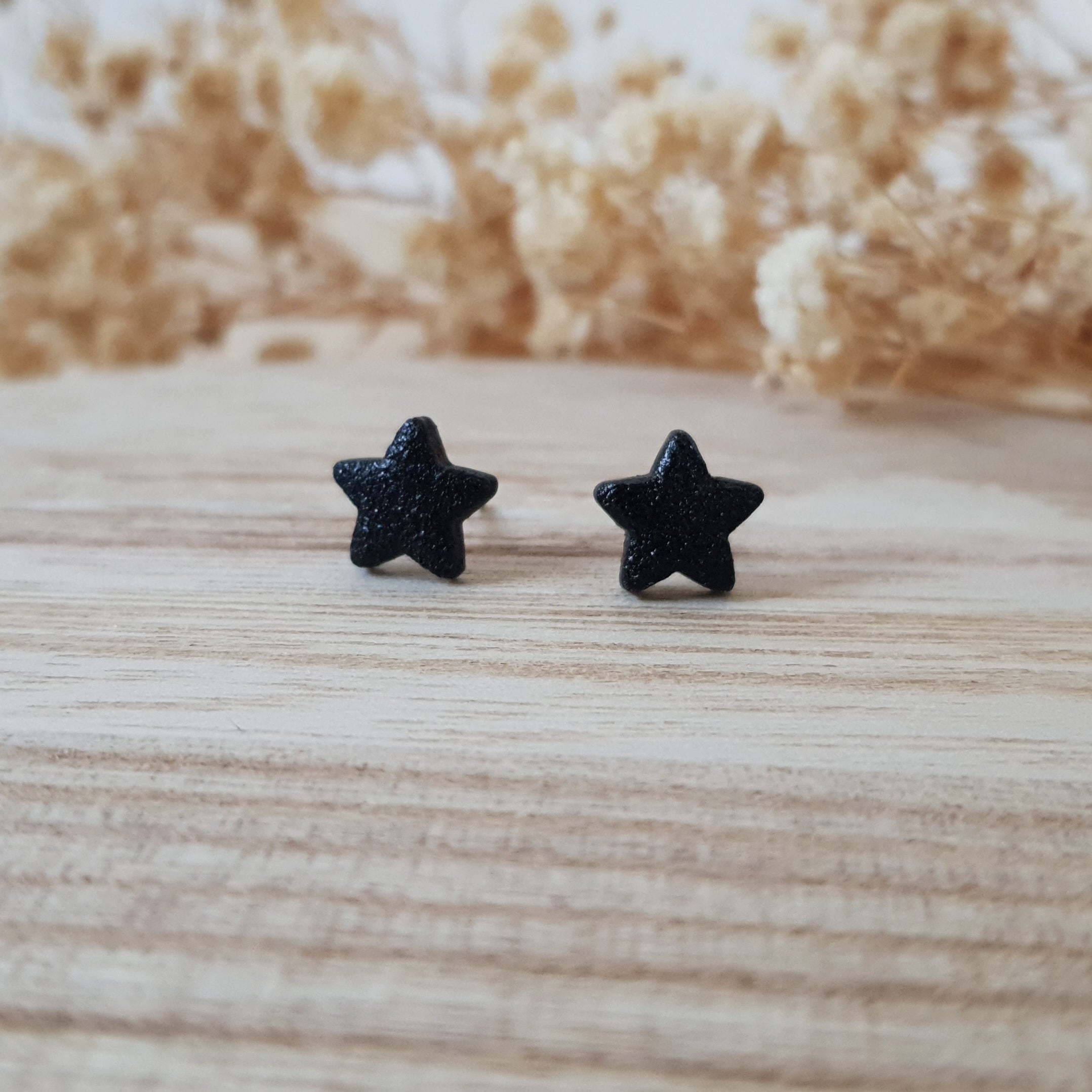 Black textured star earrings